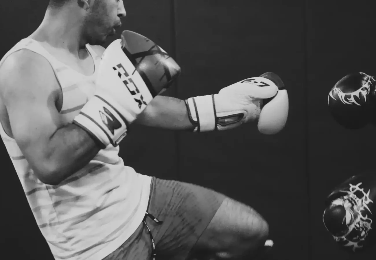 a muay thai student practicing with a trainer