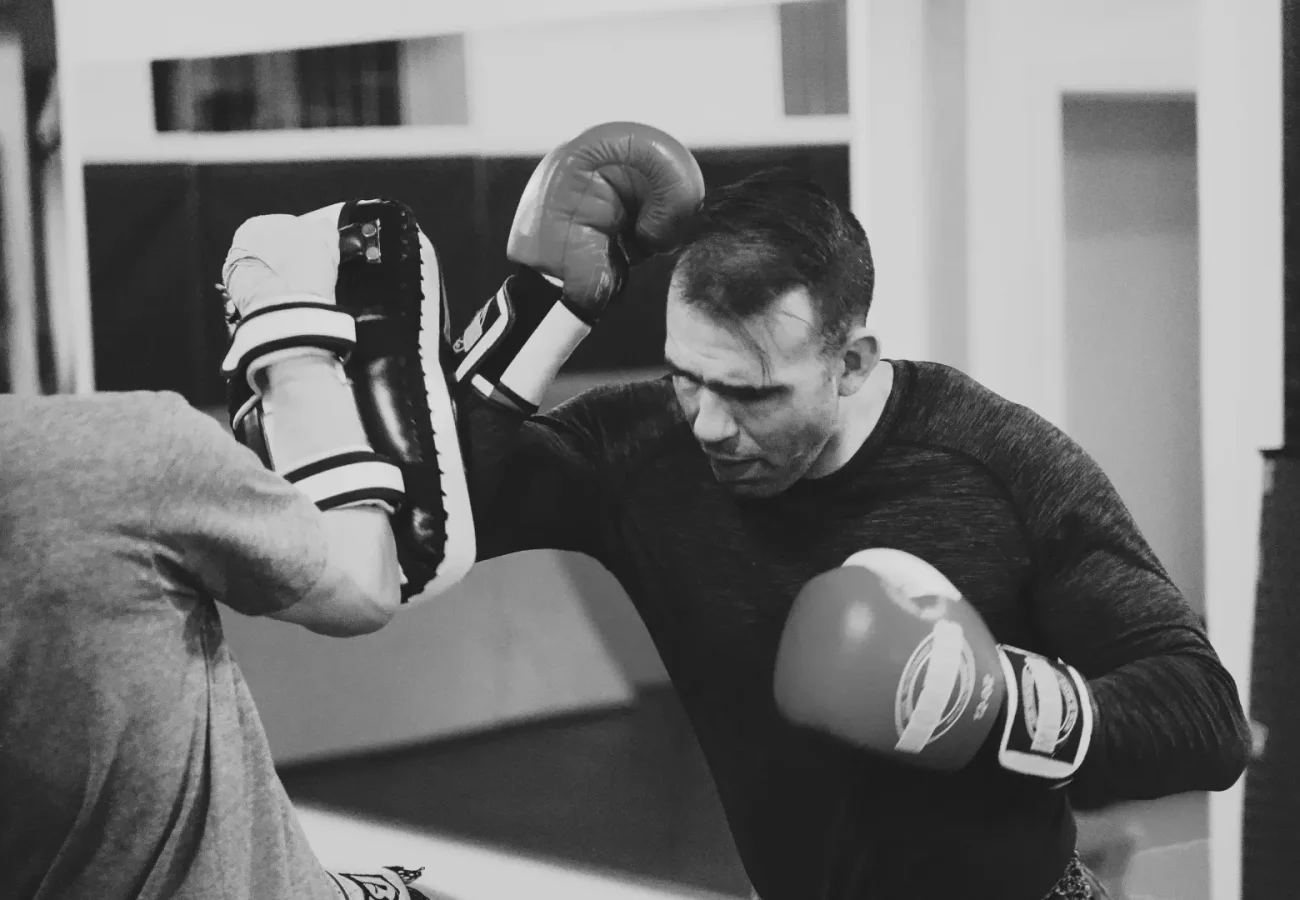 a black and white photo of a personal trainer training a student.